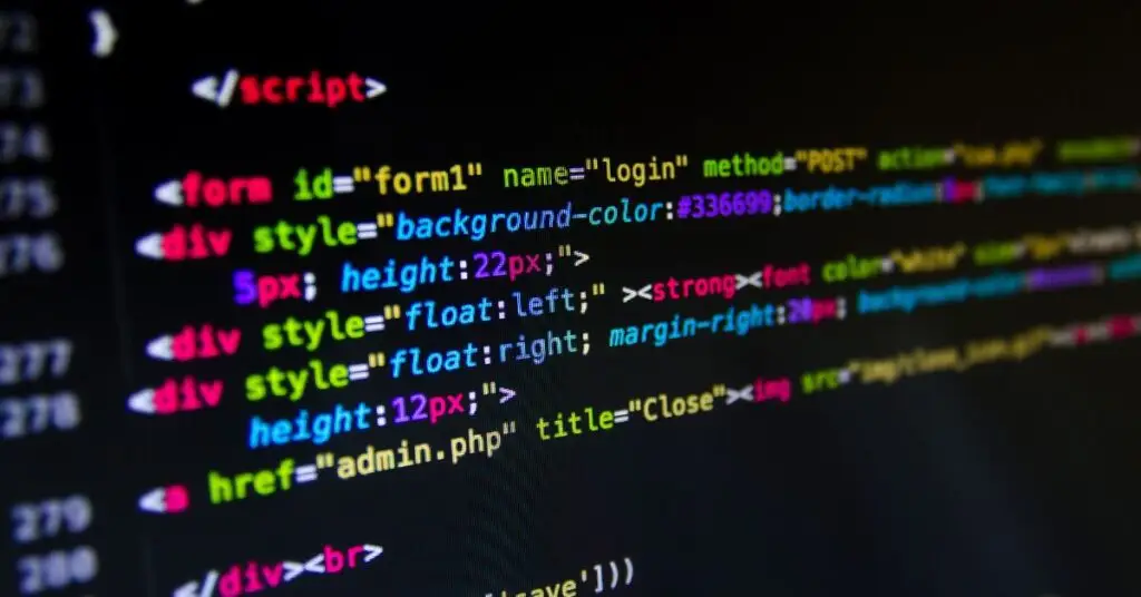 Colorful programming code and script elements on a dark background showing HTML and PHP syntax, illustrating how macros pose a cybersecurity risk through executable scripts embedded in documents. The code displays form elements, styling attributes, and script tags that could be used for malicious purposes when enabled in macro-enabled files.